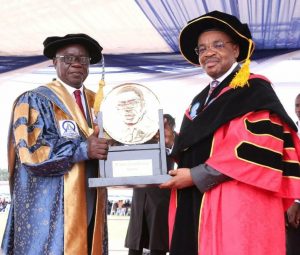Umobong presenting a plaque to Emmanuel