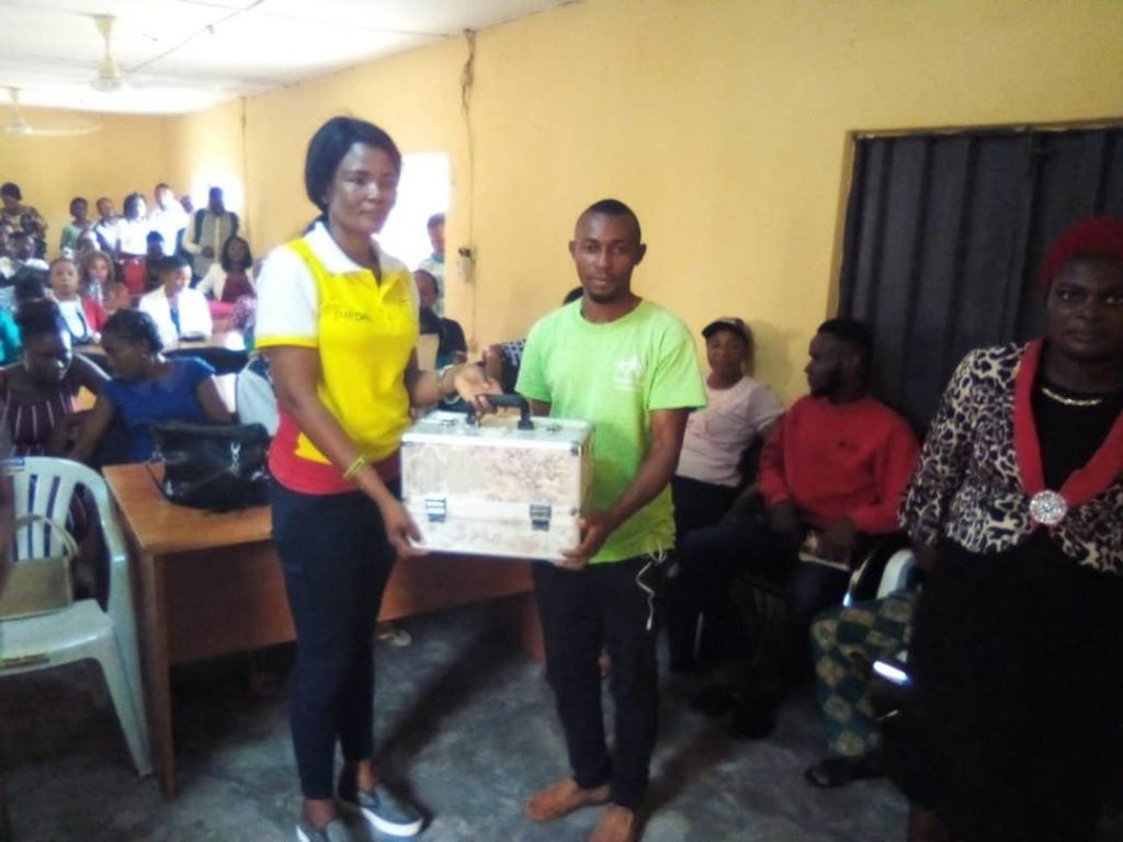 Miss Ekpenyong presenting a starter to beneficiary