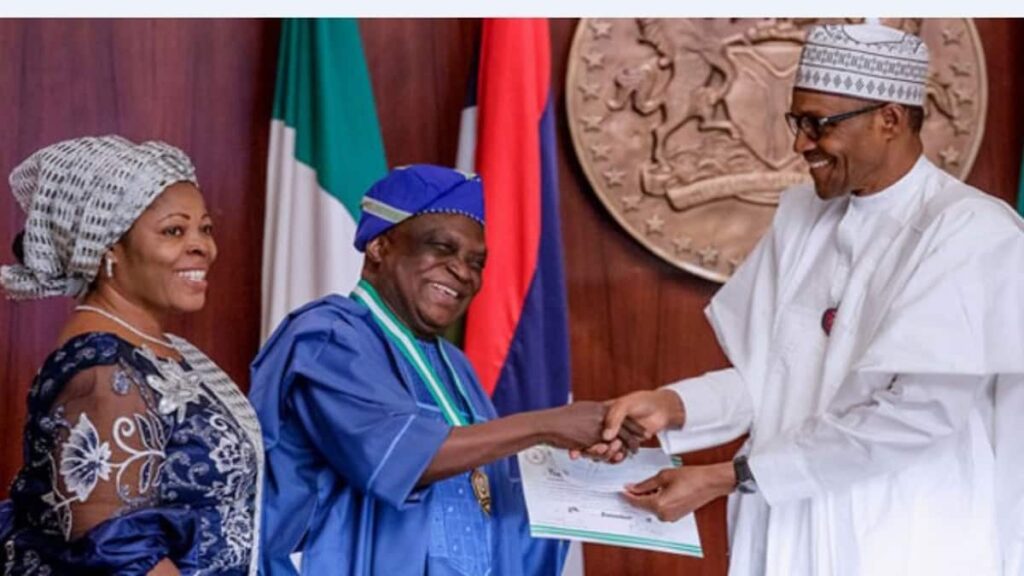 President Buhari presents 2022 National Honours on one of the recipients- straightnews