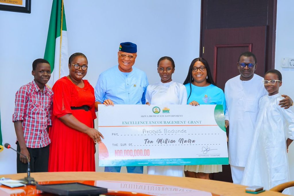 Governor Eno giving N10m cheque to the young Edo girl - Straightnews