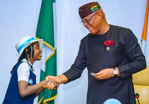 Gov Eno Reaffirms commitment to safe, secure future for Akwa Ibom children Gov Eno in a warm handshake with a pupil of the school - Straightnews