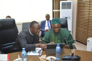 Mkposong Asuquo (left) exchanging notes with a fellow member - Straightnews