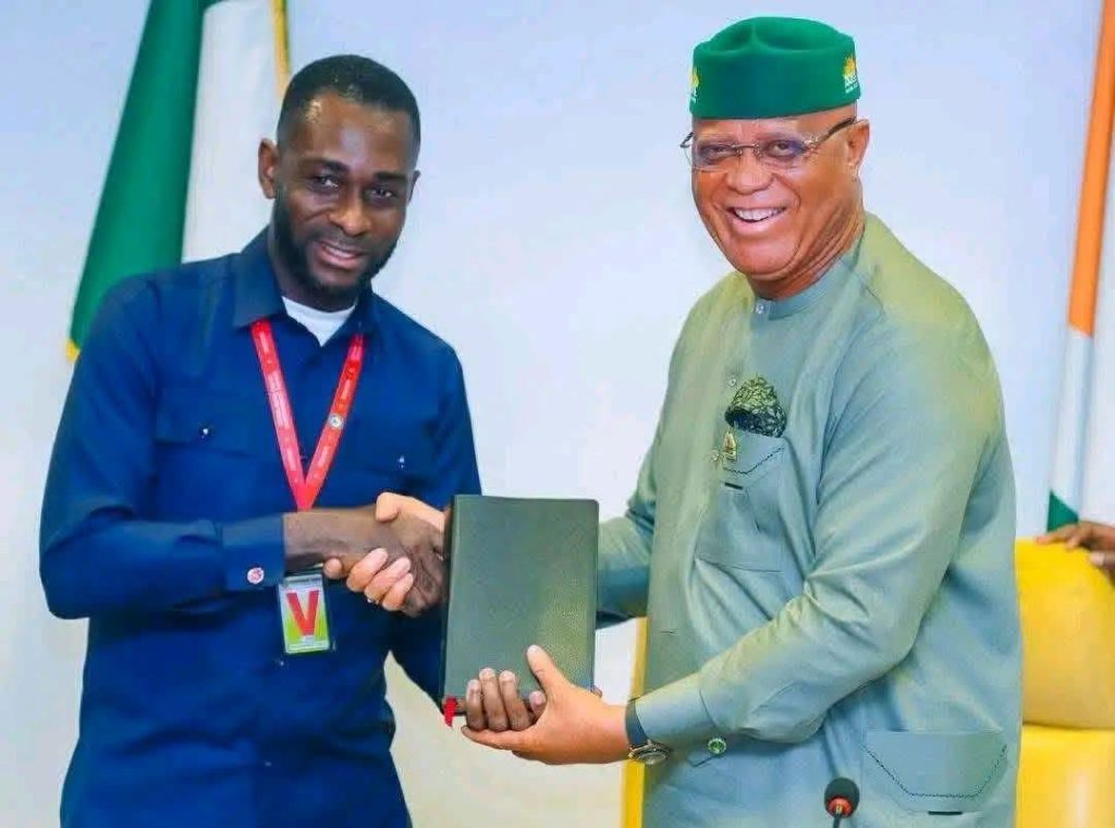 Comrade Nsibiet John receiving a plaque from Governor Umo - Straightnews Eno