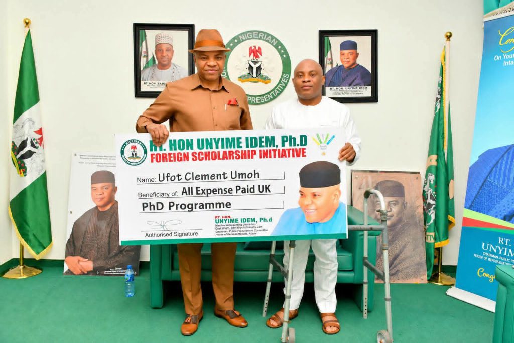Rep Offers Accident Victim Overseas PHD Scholarship Dr. Unyime Idem presenting a cheque to Ufot Ebong - Straightnews